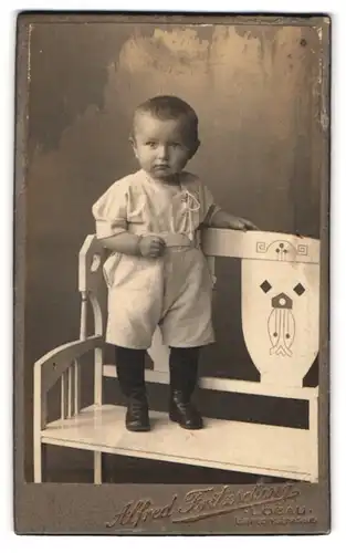 Fotografie Alfred Fritzsching, Löbau, Gartenstrasse, Portrait Kleinkind auf einer Bank, Art Deco