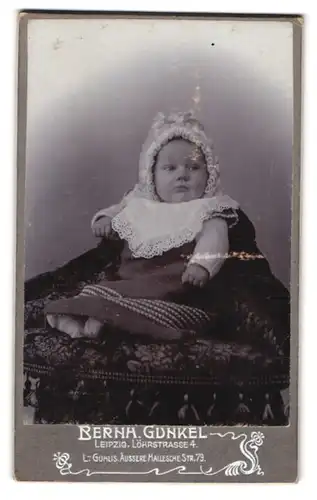 Fotografie Bernh. Gunkel, Leipzig, Löhrstrasse 4, Portrait niedliches Baby mit Mützchen und Latz