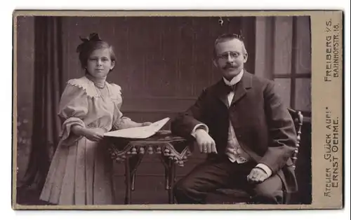 Fotografie Atelier Ernst Oehme, Freiberg i. S., Bahnhofstrasse 18, Portrait Vater mit Brille und Tochter mit Haarschleife