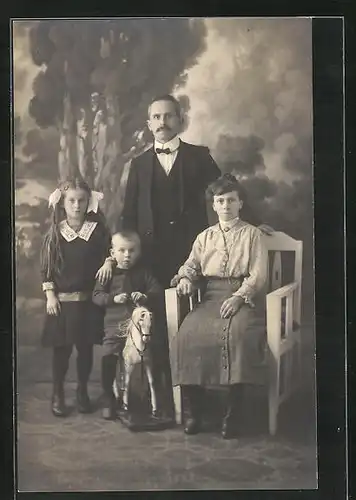 AK Schaukelpferd, Familienbild mit dem Sohn auf dem Pferd