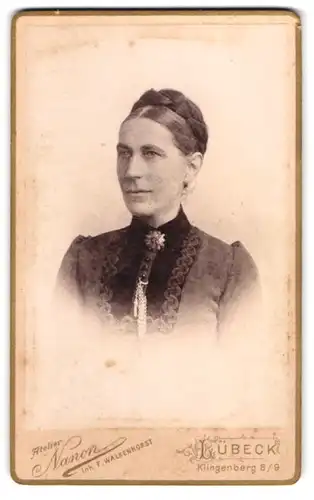 Fotografie Atelier Nanon, Lübeck, Klingenberg 8 / 9, Portrait Dame mit Flechtfrisur, Ohrringen und Brosche