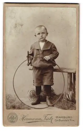 Fotografie Hermann Tietz, Hamburg, Gr. Burstah 12, Portrait Knabe in kurzen Hosen mit Spielreif