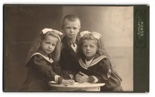 Fotografie E. Schuffert, Borna, Bahnhofstrasse 37, Portrait niedliche Zwillingsschwestern und Knabe im Matrosenanzug