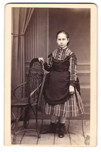 Fotografie J. C. Janda, Gelnhausen, Mädchen im karierten Kleid mit Schürze