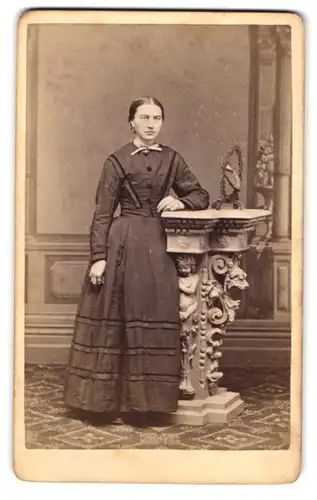 Fotografie Christ. Verra, Deggendorf, Portrait Dame im Biedermeierkleid stehend an einer Säule