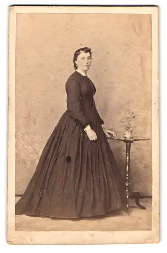 Fotografie unbekannter Fotograf und Ort, Portrait junge Frau im schwarzen Biedermeierkleid posiert im Atelier