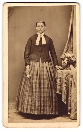 Fotografie W. Filser, Kaufbeuren, Portrait Dame im bürgerlichen Kleid mit Schleife posiert im Atelier