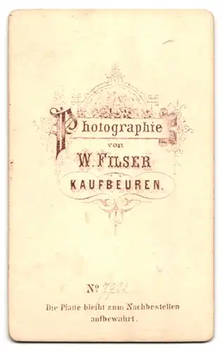 Fotografie W. Filser, Kaufbeuren, Portrait Dame im bürgerlichen Kleid mit Schleife posiert im Atelier