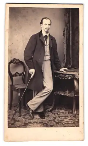 Fotografie unbekannter Fotograf und Ort, Portrait Herr im hellen Anzug mit Mantel und Flanierstock posiert