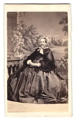Fotografie unbekannter Fotograf und Ort, Portrait Dame im Biedermeierkleid mit Haube sitzt im Atelier