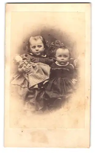 Fotografie August Linde, Gotha, Auguststr. 3, Portrait zwei niedliche Mädchen in Kleidern mit Puppe im Arm