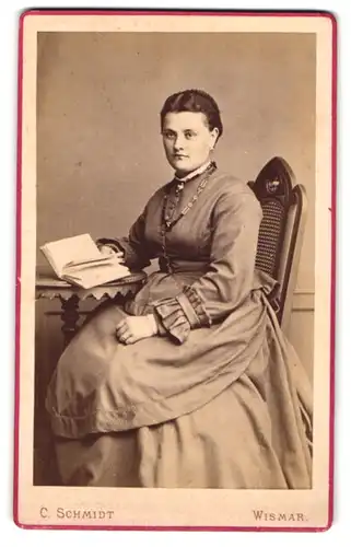 Fotografie C. Schmidt, Wismar, Portrait junge Dame im Kleid mit Buch
