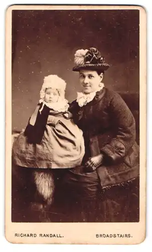 Fotografie R. Randall, Broadstairs, 4 & 5, Albion St., Portrait junge Dame in winterlicher Kleidung mit Kleinkind