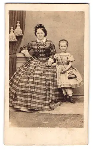 Fotografie unbekannter Fotograf und Ort, Mutter im karierten Kleid mit ihrer Tochter