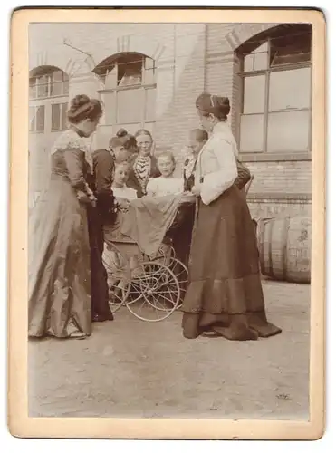 Fotografie unbekannter Fotograf und Ort, Damen & Mädchen scharen sich um Kinderwagen, Babybuggy