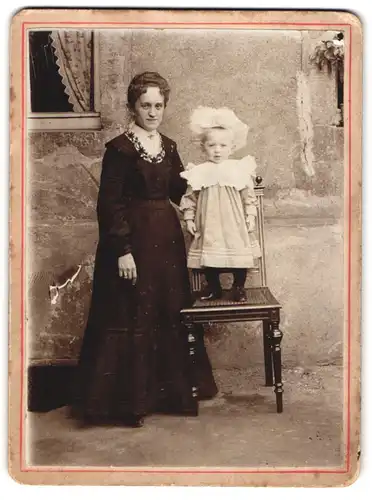 Fotografie unbekannter Fotograf und Ort, Mutter im schwarzen Kleid mit ihrem Spross im Kleidchen, Mutterglück