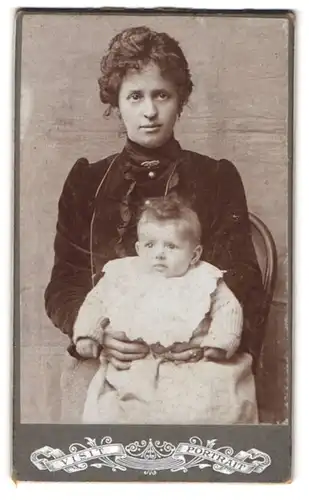 Fotografie unbekannter Fotograf und Ort, Frau im samtenen Kleid mit ihrem Kind im Arm, Mutterglück