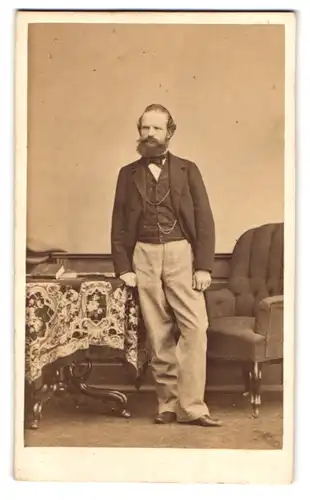Fotografie unbekannter Fotograf und Ort, Portrait Herr im Anzug mit heller Hose und Vollbart posiert im Atelier