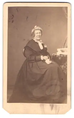 Fotografie C. H. Bartels, Hannover, Schiffgraben 16, Portrait ältere Dame im Biedermeierkleid mit Haube beim Stricken