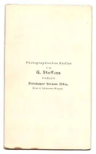 Fotografie G. Steffons, Berlin, Potsdamer Str. 116a, Portrait junger Mann im dunklen Anzug mit einem Buch am Sekretär