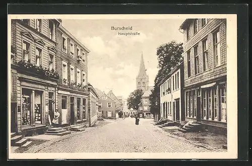 AK Burscheid, Hauptstrasse mit Geschäften und Blick zur Kirche