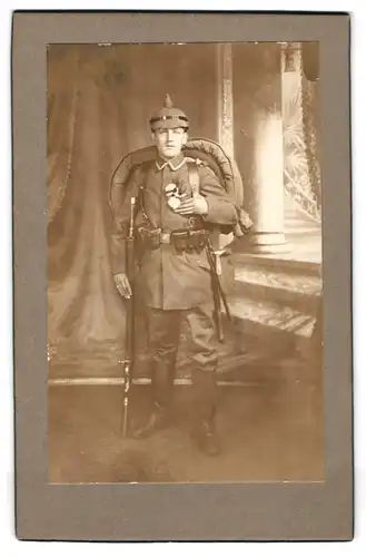 Fotografie unbekannter Fotograf und Ort, Soldat mit Ausrüstung, Gewehr, Pickelhaube zum Kriegsausmarsch