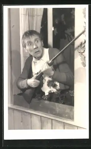 AK Schauspieler Sepp Nigg steht mit einem Gewehr am Fenster