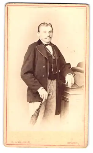 Fotografie E. Schroeter, Meissen, Obergasse 597, Portrait modisch gekleideter Herrr mit Schirm