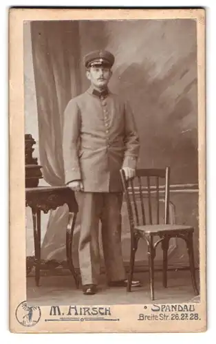 Fotografie M. Hirsch, Berlin-Spandau, Breite Str. 26-28, Portrait Postbeamter in Uniform mit Schirmmütze