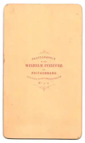 Fotografie Wilhelm Pfeiffer, Reichenberg, Bursche mit Brille im Anzug mit Mantel