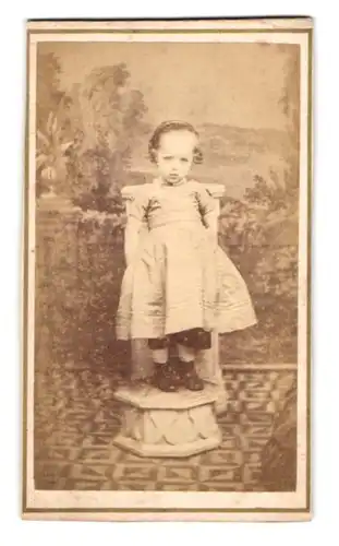 Fotografie Joseph Adams, Simmern, Portrait niedliches Mädchen im hellen Kleid steht auf einem Sockel
