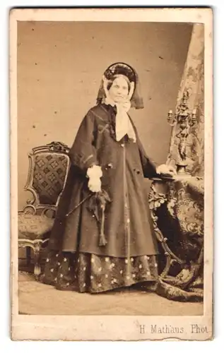 Fotografie H. Mathaus, München, Schwanthaler Str. 4, Portrait ältere Dame im Mantel mit Haube