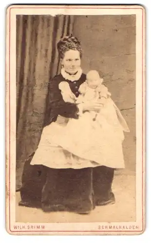 Fotografie Wilh. Grimm, Schmalkalden, Portrait junge Mutter im Samtkleid präsentiert ihr Töchterchen, Mutterglück