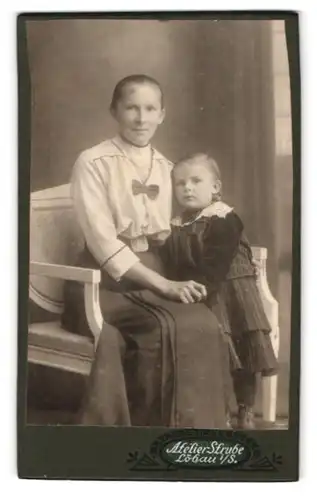 Fotografie Atelier Strube, Löbau i. Sa., Portrait Mutter mit Töchterchen im gestreiften Kleid, Mutterglück
