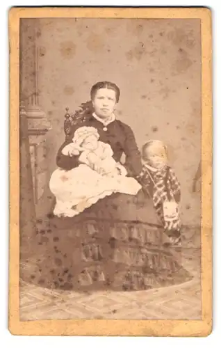 Fotografie unbekannter Fotograf und Ort, Portrait junge Mutter mit Tochter und Kleinkind auf dem Schoss