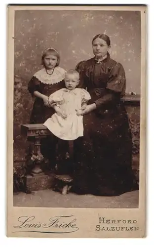Fotografie Louis Fricke, Herford, Portrait Mutter mit zwei kleinen Kindern im Atelier, Mutterglück