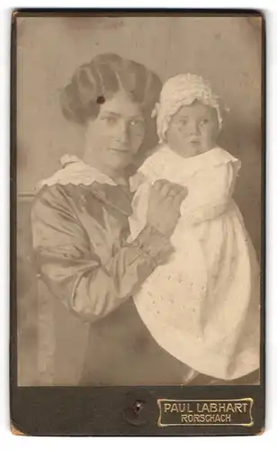 Fotografie Paul Labhart, Rorschach, Portrait junge Mutter in seidener Bluse mit Tochter im weissen Kleid, Mutterglück