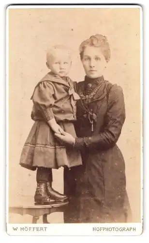 Fotografie W. Höffert, Hannover, Portrait junge Mutter im Biedermeierkleid mit Tochter auf dem Tisch, Mutterglück