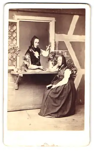 Fotografie Wilh. Schlatterer, Calw, Marktplatz, zwei Damen in Trachtenkelidern in einer Studiokulisse