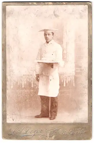 Fotografie L. A. Dozer, Bucyrus / Ohio, Portrait Knabe als Konditor Lehrling mit Törtchen auf Tablett