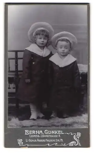 Fotografie Bernh. Gunkel, Leipzig, Löhrstr. 4, Portrait niedlichen Kinder in Wintermänteln mit breitkrempigen Hüten