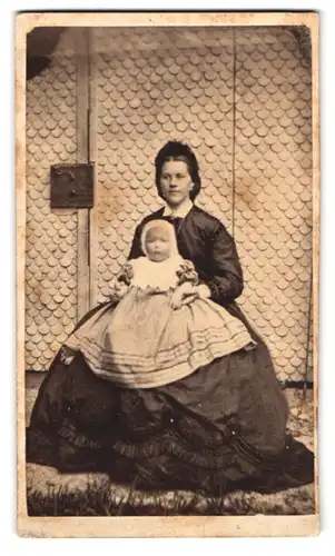 Fotografie unbekannter Fotograf und Ort, Portrait junge Mutter im Reifrockkleid mit Töchterchen auf dem Schoss