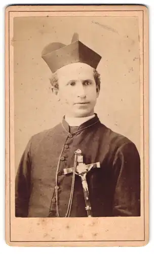 Fotografie unbekannter Fotograf und Ort, Portrait junger Pastor im Talar mit grossen Kruzifix und Birett