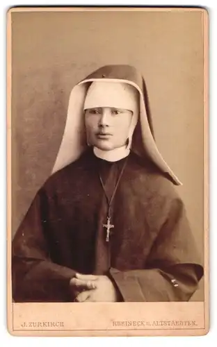 Fotografie J. Zurkirch, Rheineck, Portrait junge Nonne im Habit mit Kruzifix um den Hals