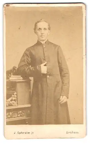 Fotografie J. Ephraim jr., Arnhem, Portrait junger Pfarrer im Talar posiert