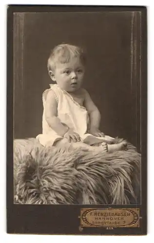 Fotografie F. Renziehausen, Hannover, Langelaube 2, Portrait süsses Kleinkind im weissen Hemd sitzt auf Fell