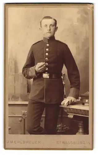 Fotografie J. Mehlbreuer, Strassburg i. E., junger Soldat in Uniform mit Bajonett und Portepee raucht Zigarre