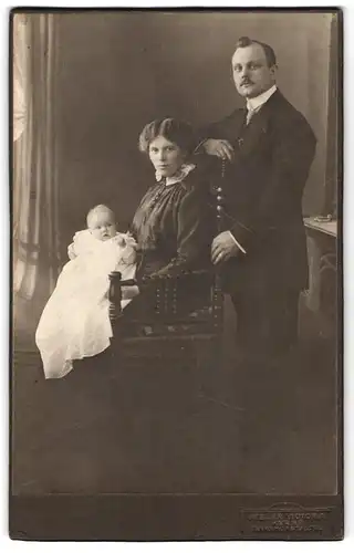 Fotografie Atelier Victoria, Herne, Bahnhofstr. 78, Portrait Mutter und Vater mit Kleinkind im Kleidchen, Mutterglück