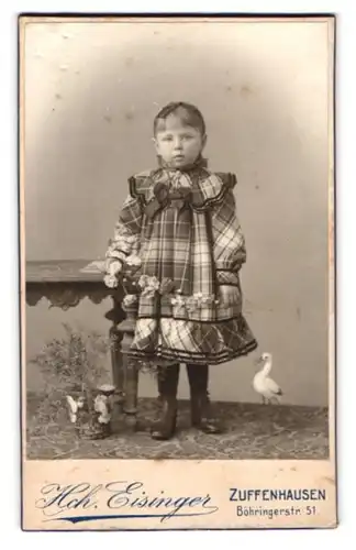 Fotografie Hch. Eisinger, Zuffenhausen, Böhringerstr. 51, Portrait niedliches Mädchen im Kleid mit Storch Figur