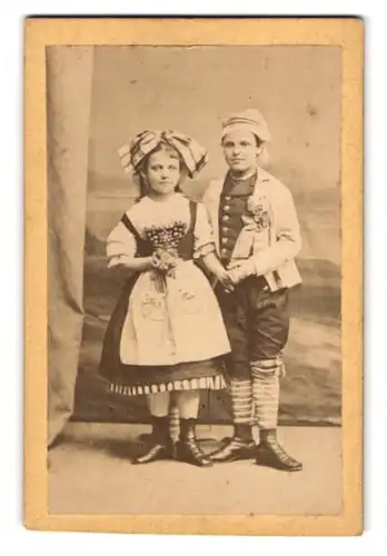 Fotografie unbekannter Fotograf und Ort, Portrait zwei Kinder in Trachtenkostümen zum Fasching halten Händchen